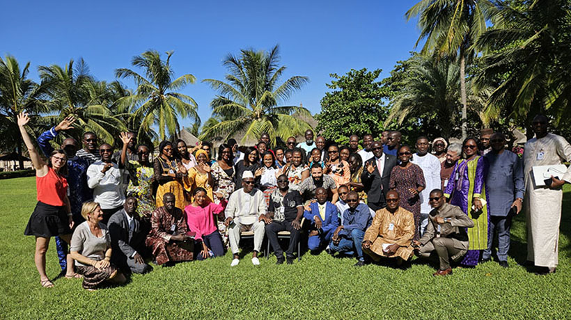 Participants from the course standing on grass with trees on both sides